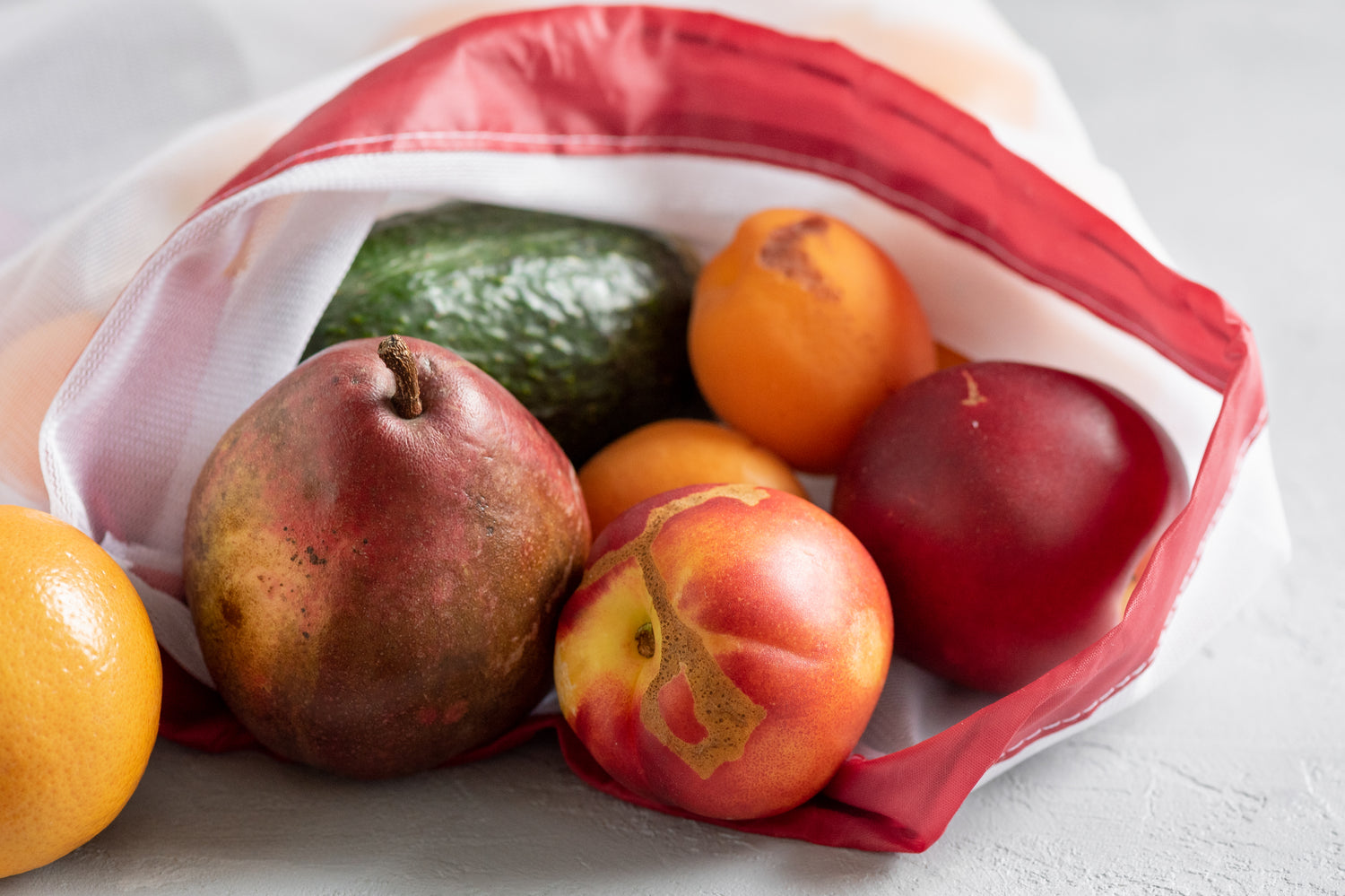 imperfect fruit spilling out of grocery bag