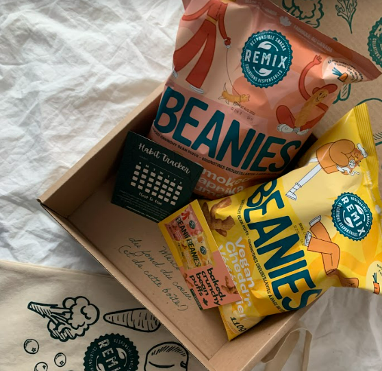 bags of beanies and a postcard and tote bag in a box